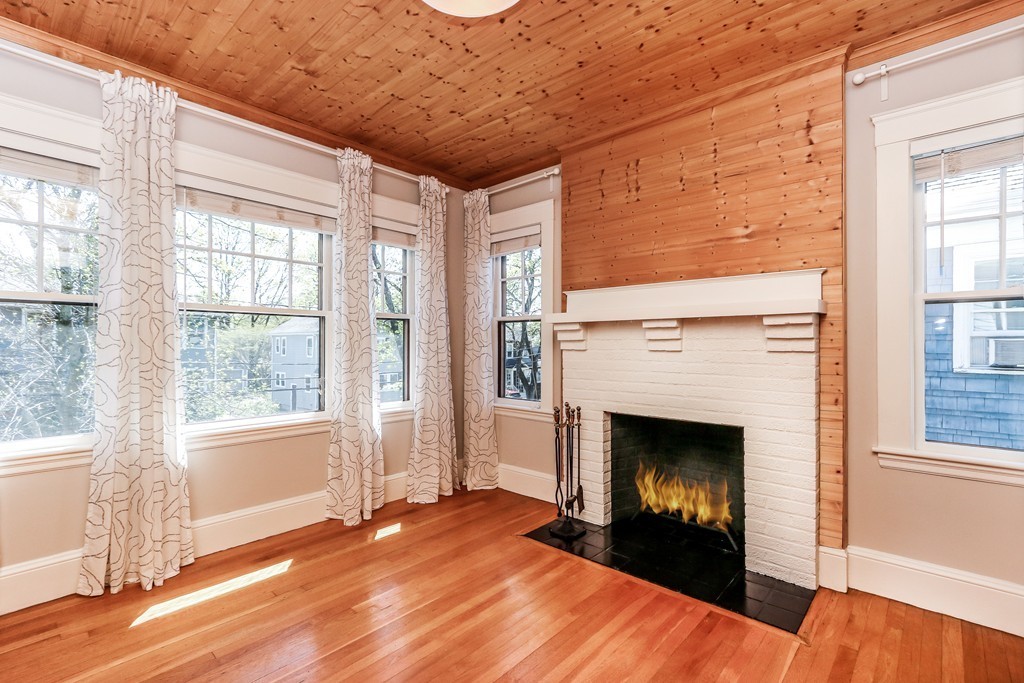 109 Adena Road, Unit 109 Newton, MA 02465 - Photo 6 of 23 a view of an empty room with wooden floor fireplace and a window