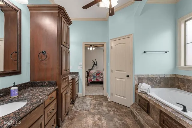 a bathroom with a granite countertop tub sink and mirror