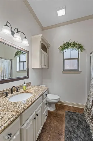 a bathroom with a granite countertop sink mirror and toilet