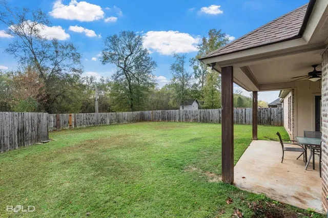 a view of a backyard with a slide trees and wooden fence