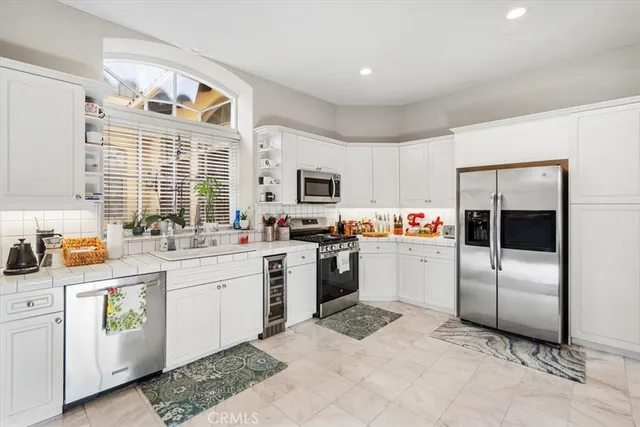 a kitchen with a refrigerator and white cabinets