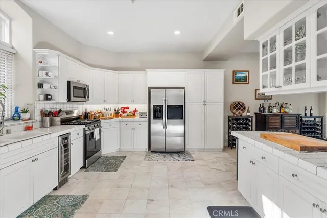 a kitchen with granite countertop a refrigerator stove top oven and sink
