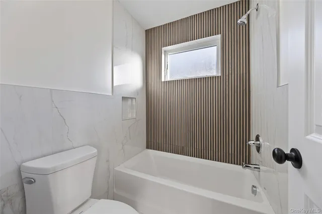 a white toilet sitting next to a bathroom sink