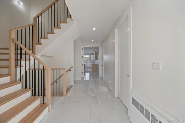 a view of a hallway with wooden floor and entryway