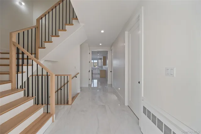 a view of a hallway with wooden floor and entryway