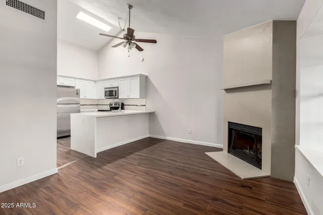 a kitchen with stainless steel appliances granite countertop a stove top oven a sink and a fireplace with wooden floor