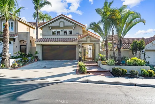 a front view of a house with garage and plants