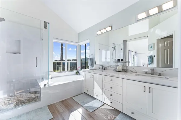 a bathroom with a granite countertop sink mirror and a bathtub