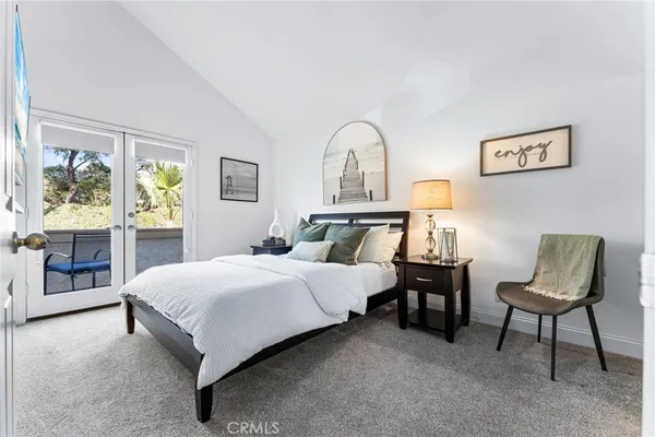 a bedroom with a bed a table and painting on the wall