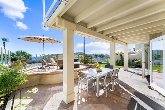 a view of a patio with a table and chairs under an umbrella