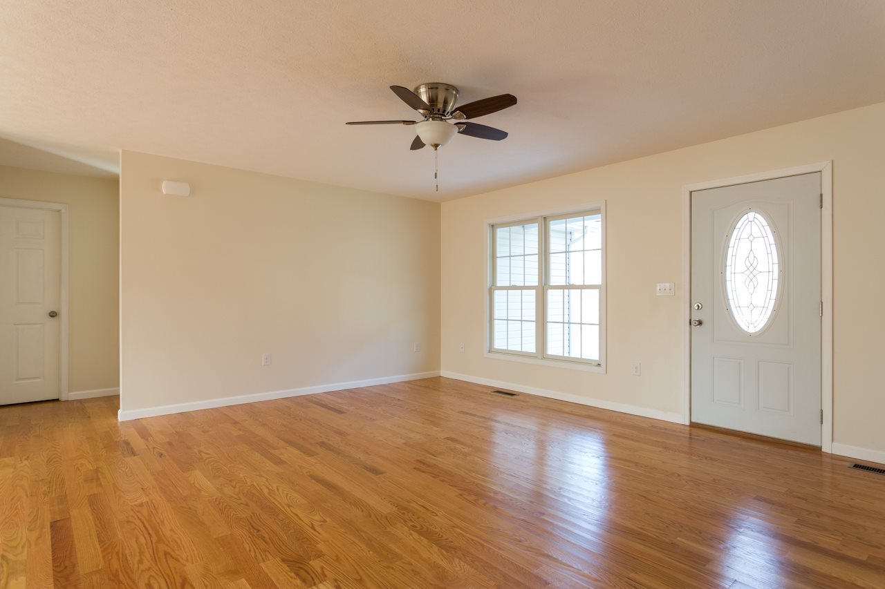227 Harriston Road Grottoes, VA 24441 - Photo 5 of 25 an empty room with wooden floor fan and windows