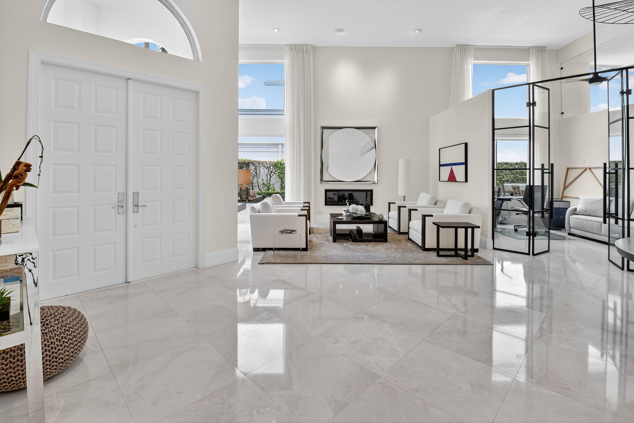 2563 Northwest 63rd Street Boca Raton, FL 33496 - Photo 4 of 65 a living room with furniture a large window and a chandelier