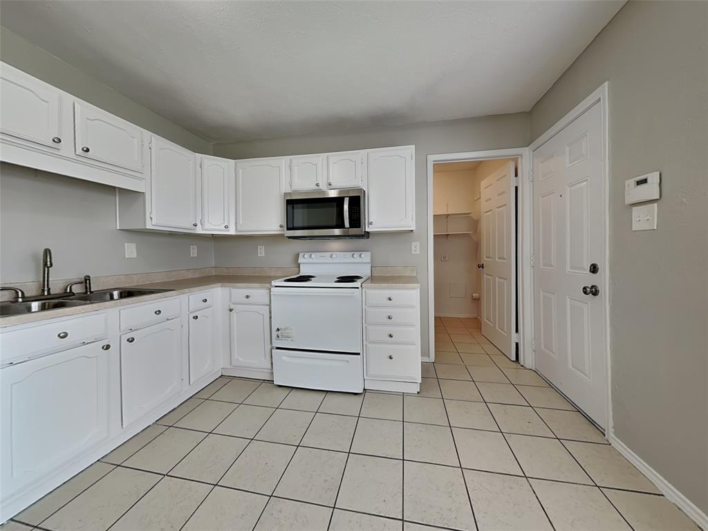 7621 Pebble Beach Drive Rowlett, TX 75088 - Photo 5 of 20 a kitchen with stainless steel appliances a stove top oven cabinets a sink and a refrigerator