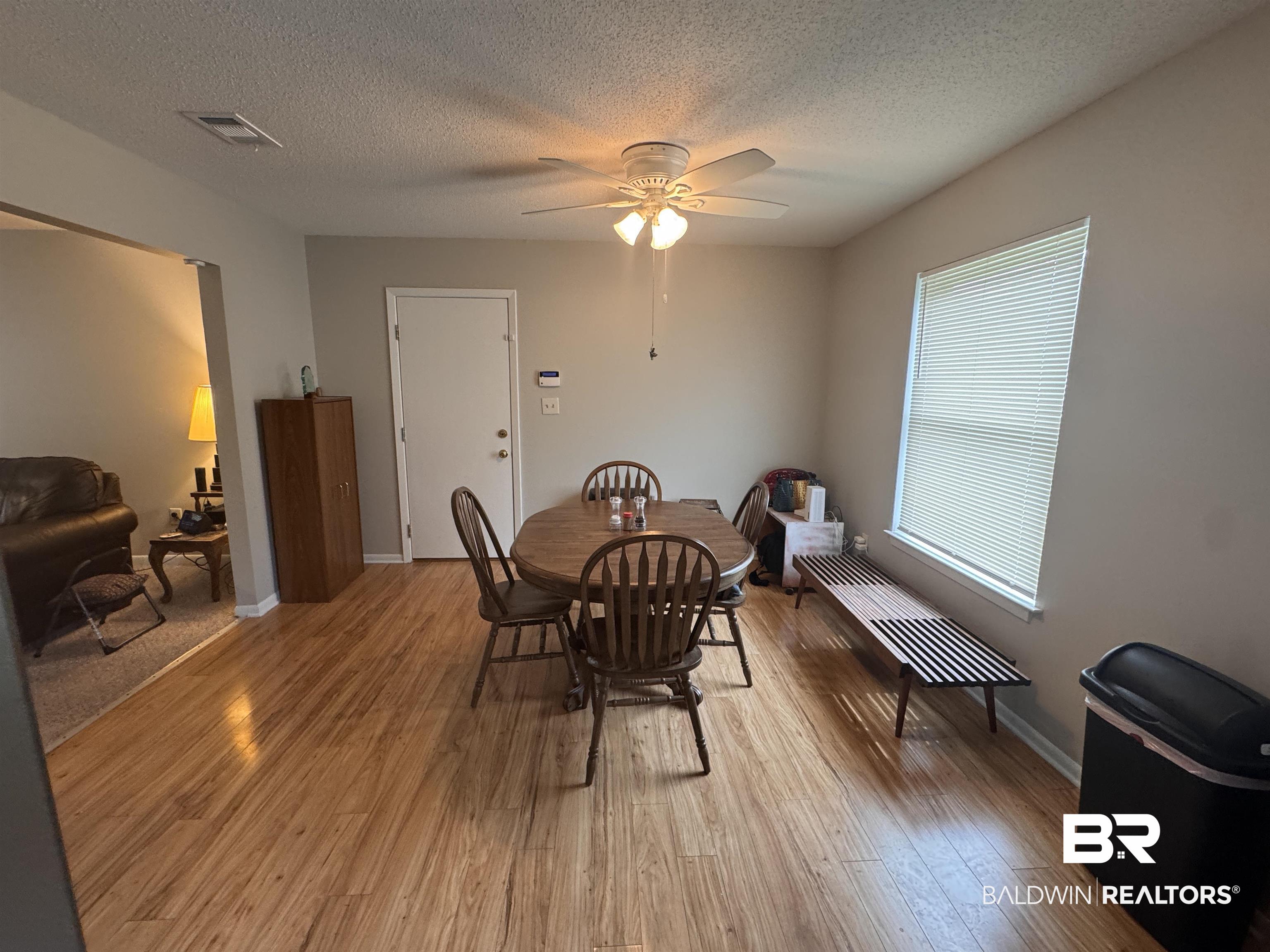 15148 Highland Circle Foley, AL 36535 - Photo 15 of 47 Dining room featuring light wood-style floors, a ceiling fan, a textured ceiling, and baseboards