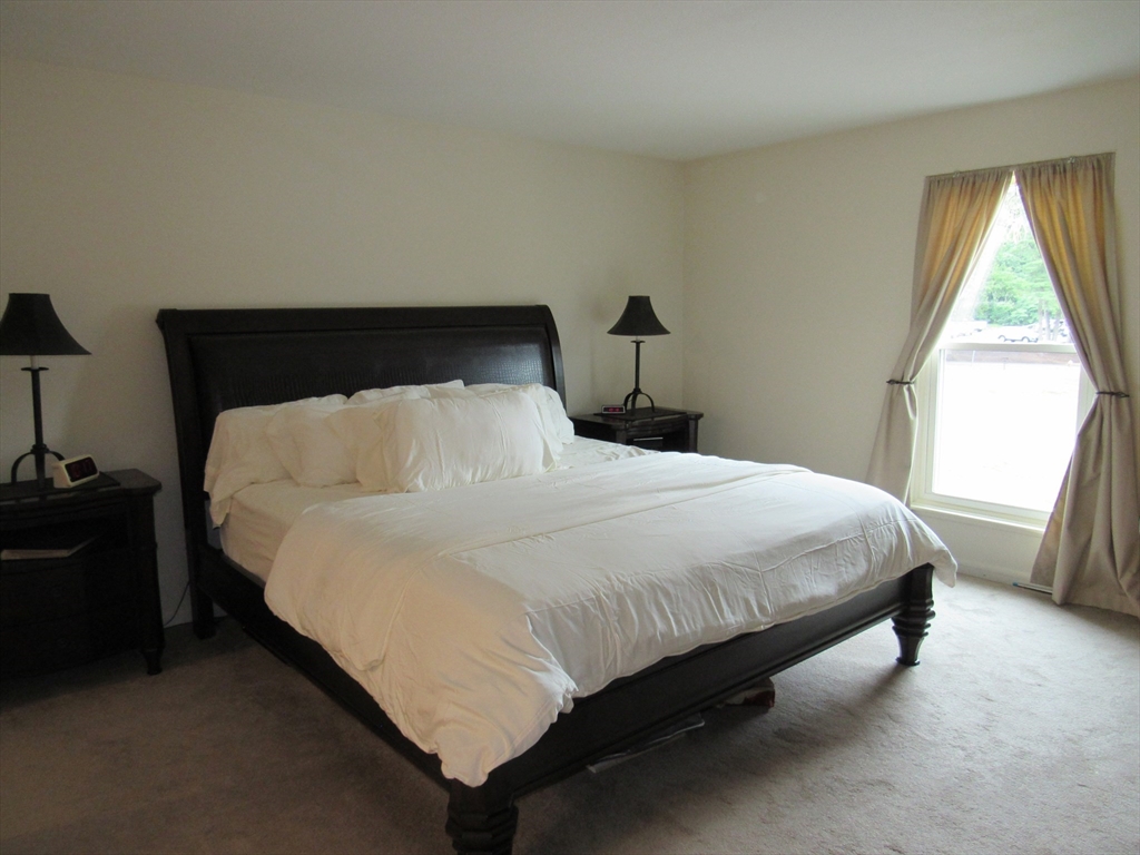 2 Shadowbrook Lane, Unit 50 Milford, MA 01757 - Photo 14 of 26 a large bed sitting in a bedroom next to a window