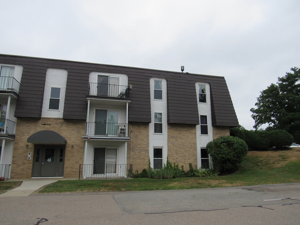 2 Shadowbrook Lane, Unit 50 Milford, MA 01757 - Photo 2 of 26 a front view of a house with a garden