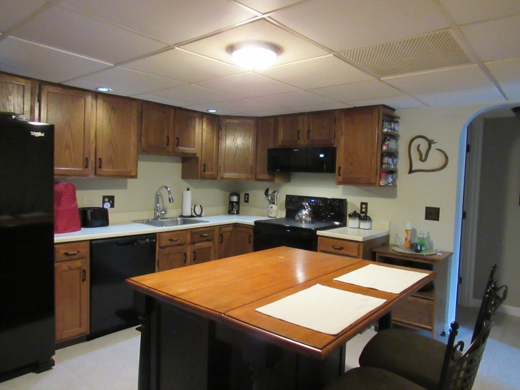 2 Shadowbrook Lane, Unit 50 Milford, MA 01757 - Photo 4 of 26 a kitchen with stainless steel appliances granite countertop a sink a stove top oven a counter space and cabinets