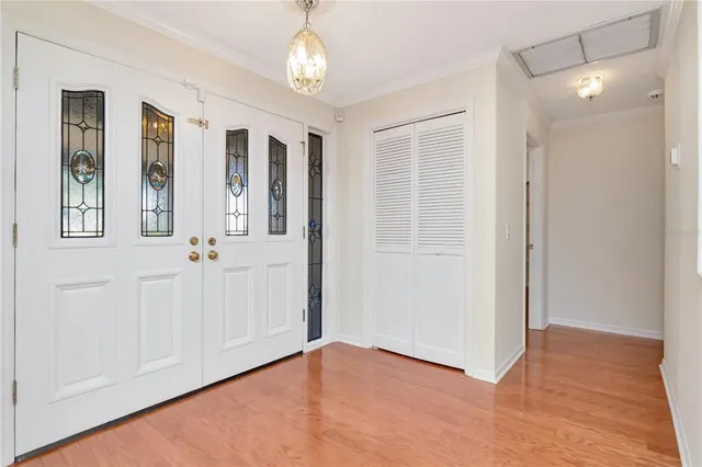 an empty room with wooden floor mirror and windows