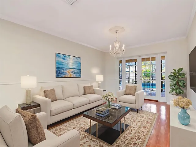 a living room with furniture a chandelier and a window