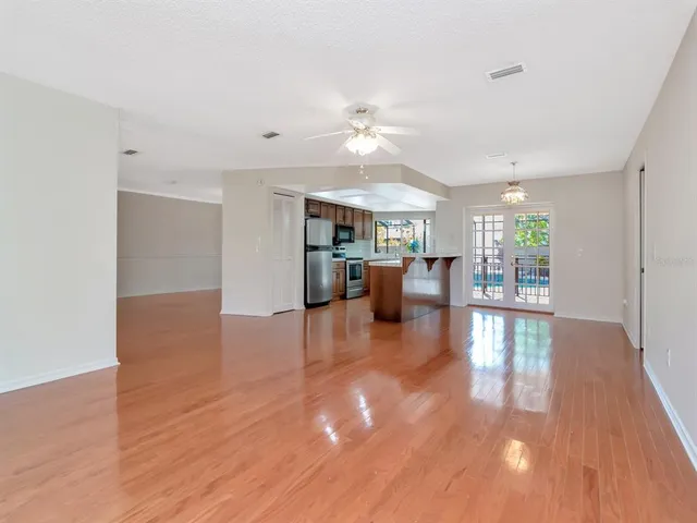 a kitchen with stainless steel appliances granite countertop a refrigerator a stove a sink dishwasher and a refrigerator with wooden floor