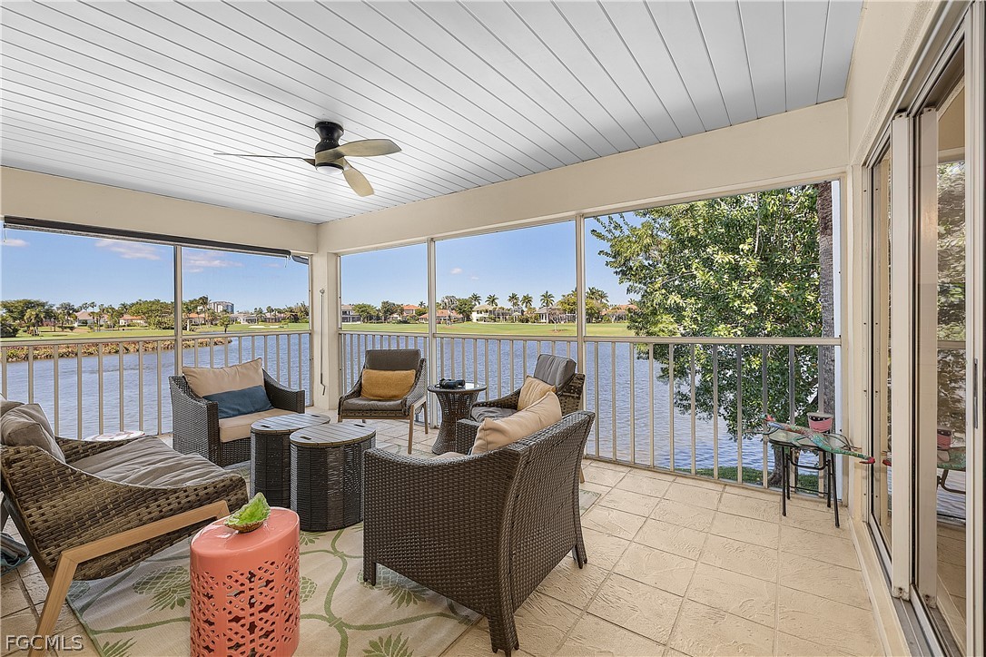 a living room with furniture floor to ceiling window and outdoor view