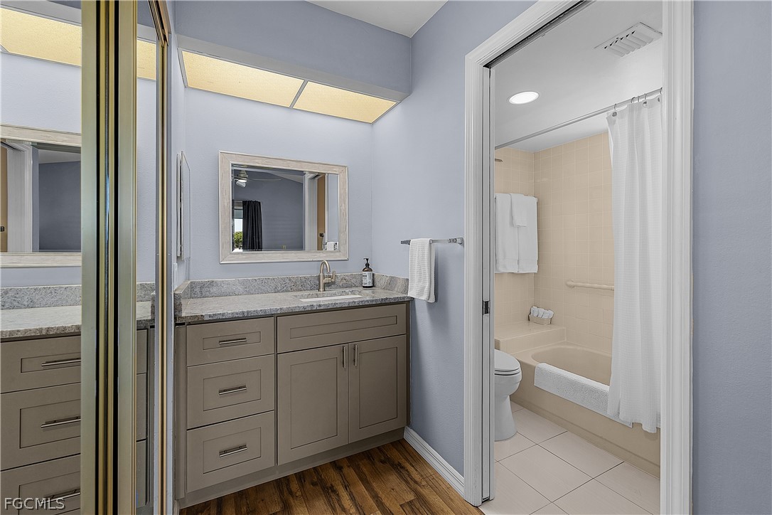 14983 Rivers Edge Court, Unit 232 Fort Myers, FL 33908 - Photo 14 of 27 a bathroom with a granite countertop sink mirror and a bathtub