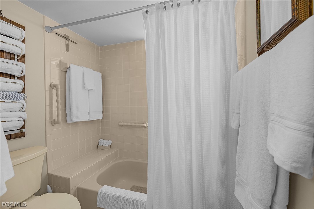 14983 Rivers Edge Court, Unit 232 Fort Myers, FL 33908 - Photo 15 of 27 a bathroom with a shower curtain and a sink