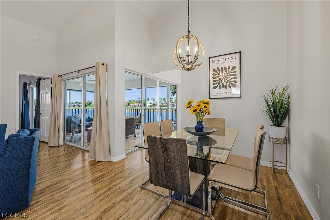 14983 Rivers Edge Court, Unit 232 Fort Myers, FL 33908 - Photo 7 of 27 a view of a dining room with furniture wooden floor and chandelier