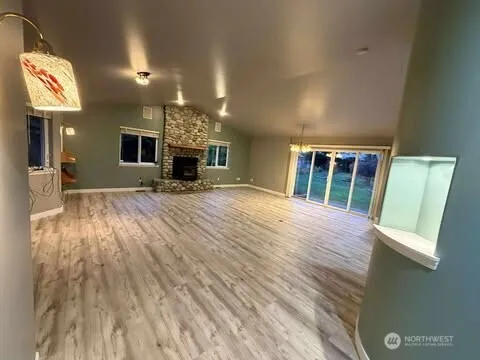 a view of a livingroom with furniture a fireplace and windows