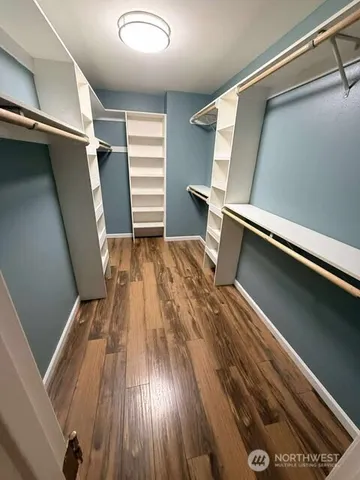 a view of closet with wooden floor and stairs