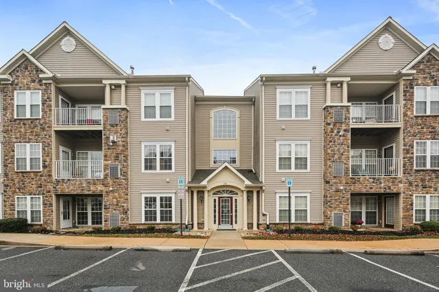 a view of a big house in a big yard and large tree
