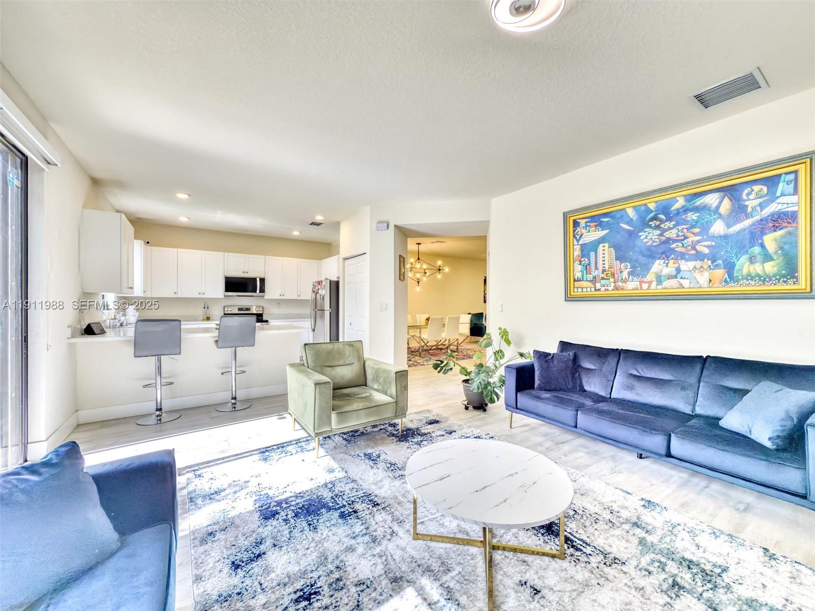 10583 West 35th Way, Unit 10583 Hialeah, FL 33018 - Photo 28 of 48 a living room with furniture or kitchen view and a wooden floor