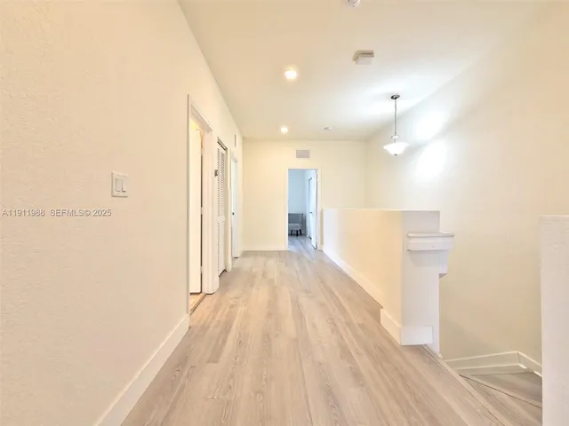 a view of a hallway with wooden floor
