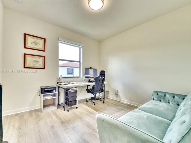 a view of a workspace with furniture and a window