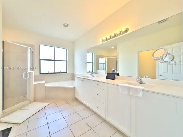 a bathroom with a granite countertop sink mirror and bathtub