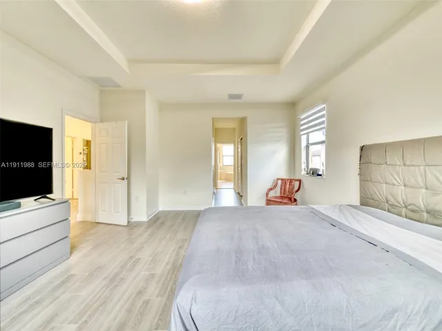 a large bedroom with a bed and a flat screen tv