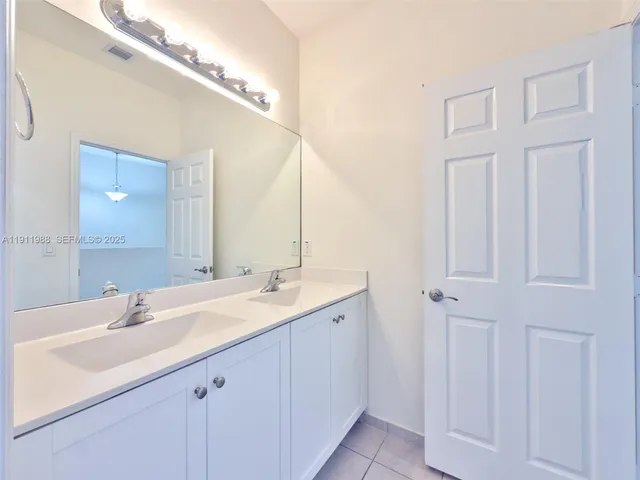 a bathroom with a double vanity sink and a mirror