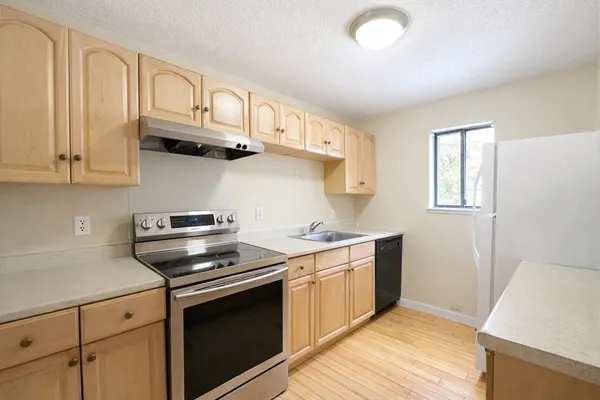a kitchen with stainless steel appliances granite countertop a sink a stove and cabinets