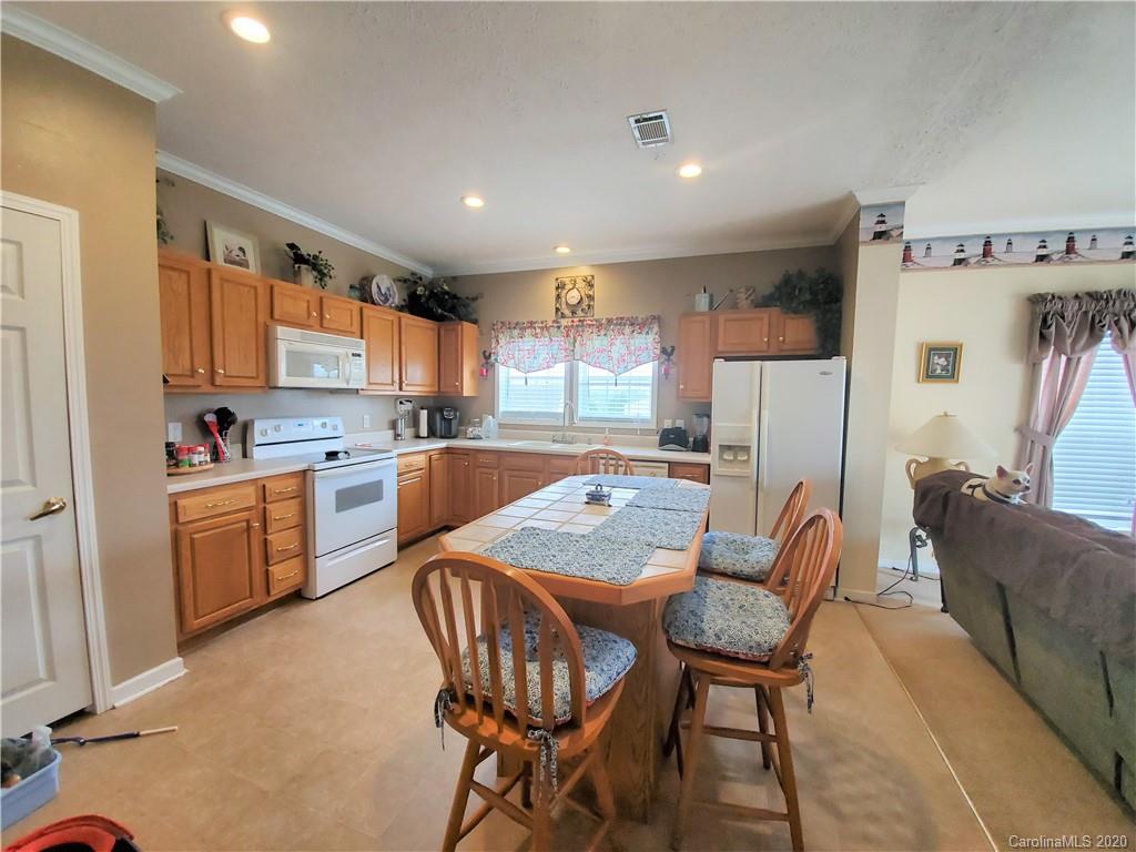 340 Weaver Road Salisbury, NC 28147 - Photo 19 of 23 a kitchen with a dining table chairs refrigerator and cabinets