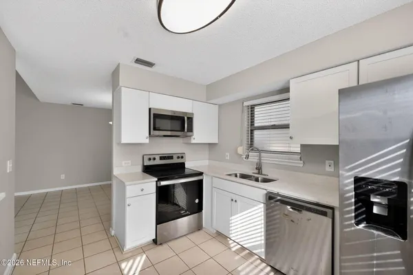 a kitchen with stainless steel appliances a sink a stove a microwave and cabinets