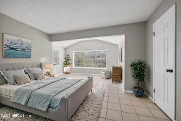 a large bedroom with a bed and a large window