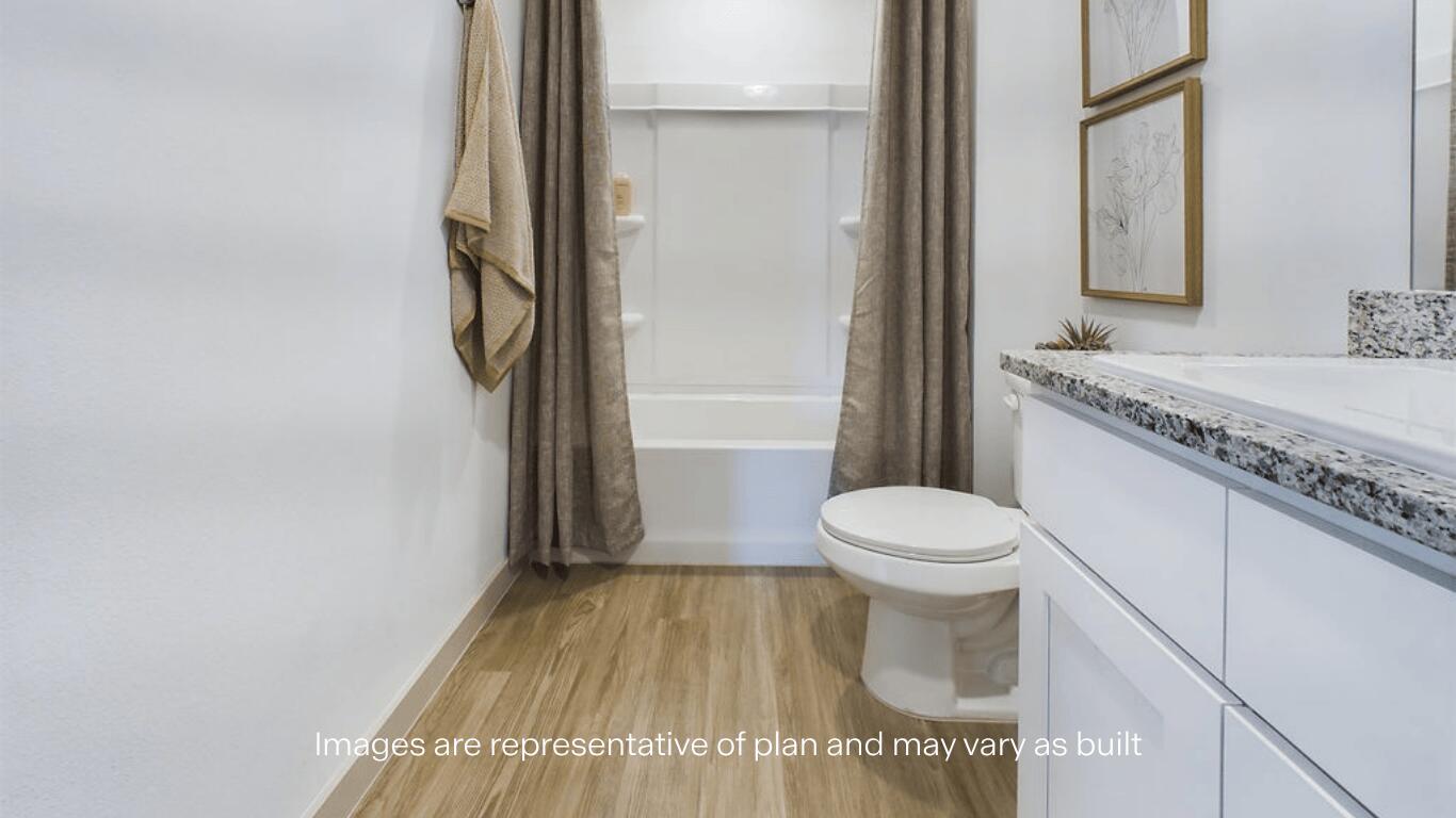 7450 9th Street Lubbock, TX 79416 - Photo 21 of 23 a bathroom with a granite countertop toilet a sink and a mirror