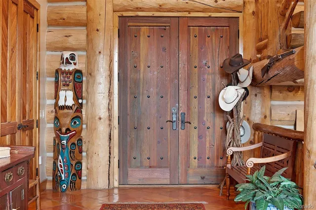 a living room with furniture a large window and a chandelier