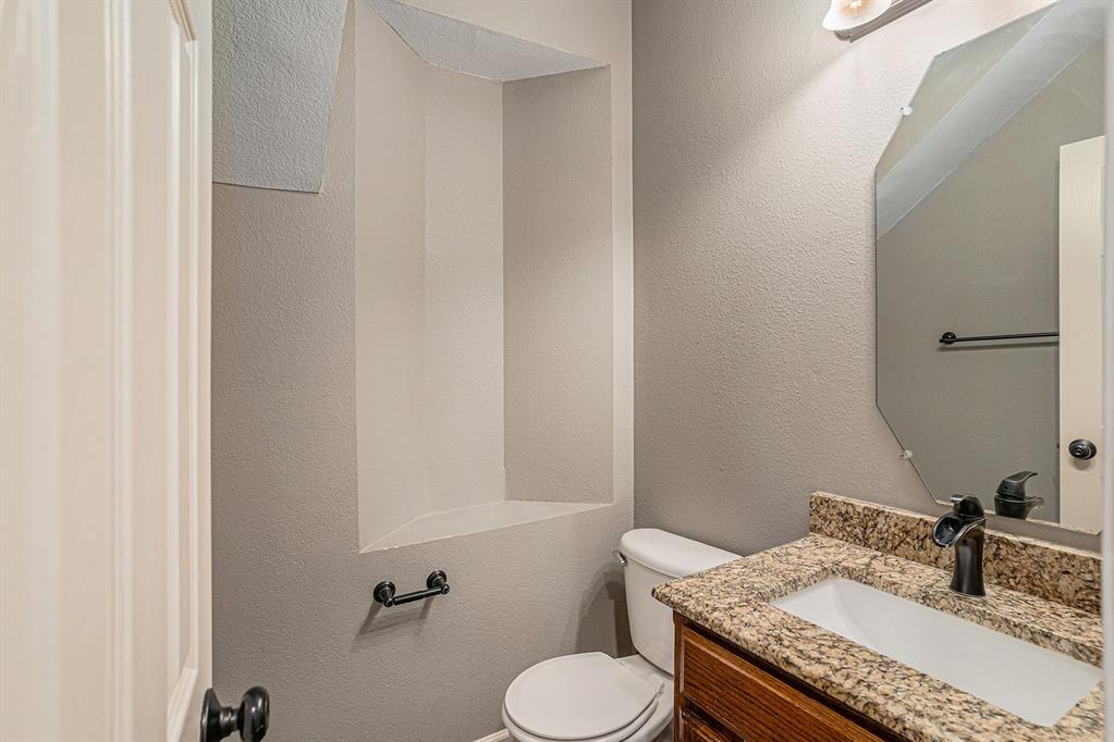 10005 Shelburne Road Fort Worth, TX 76244 - Photo 13 of 26 a bathroom with a granite countertop toilet sink and mirror