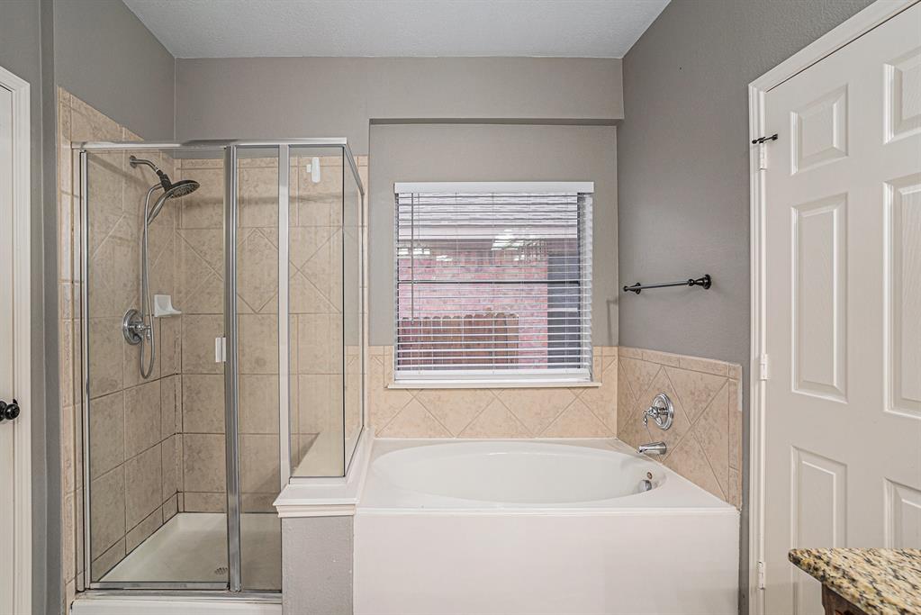 10005 Shelburne Road Fort Worth, TX 76244 - Photo 16 of 26 a bathroom with a bathtub and shower