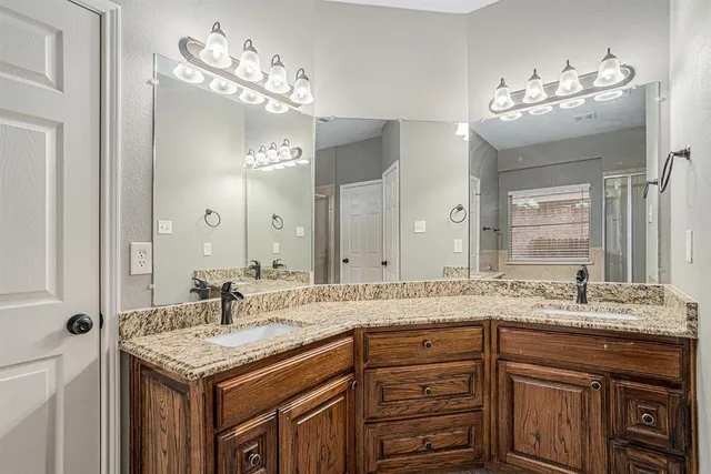 a bathroom with a granite countertop sink a large mirror and a vanity