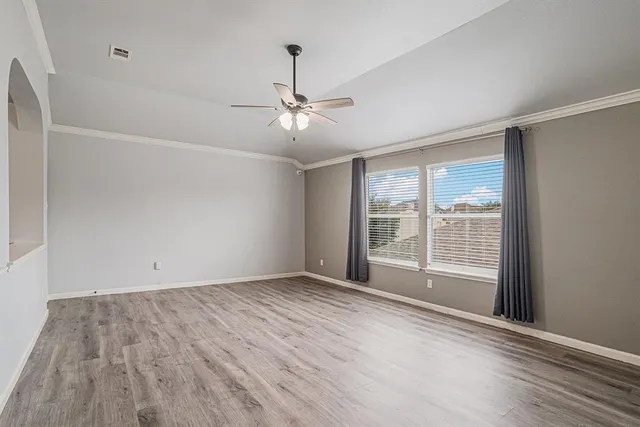a view of an empty room with a window and a ceiling fan
