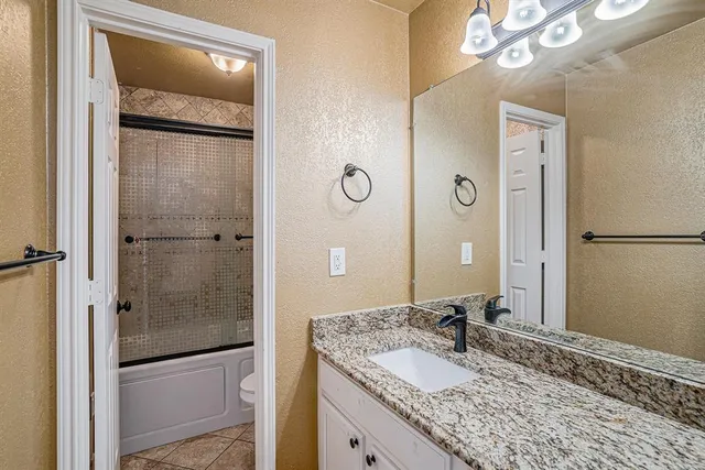 a bathroom with a granite countertop sink mirror and shower