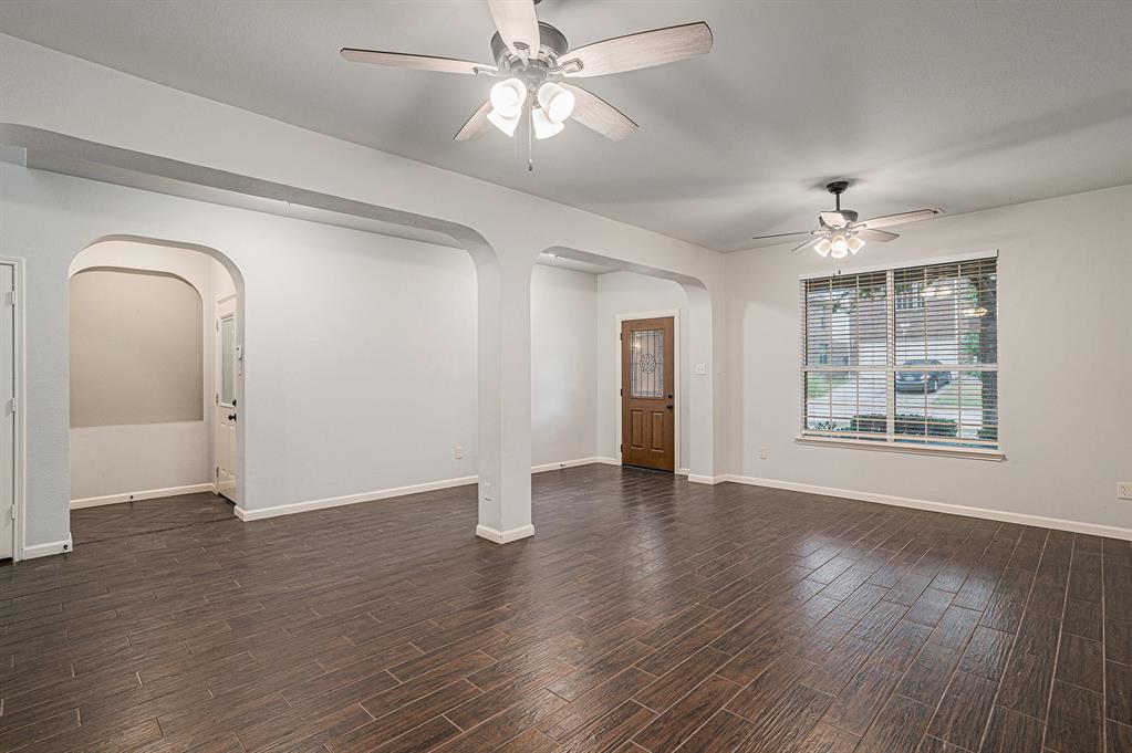 10005 Shelburne Road Fort Worth, TX 76244 - Photo 4 of 26 a view of an empty room with wooden floor and a window