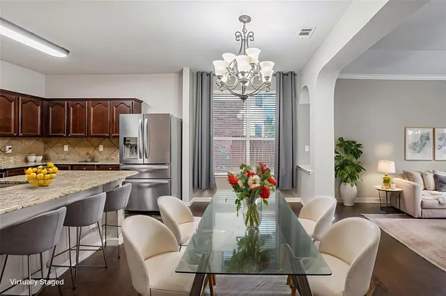 a dining room with furniture a kitchen chandelier and wooden floor